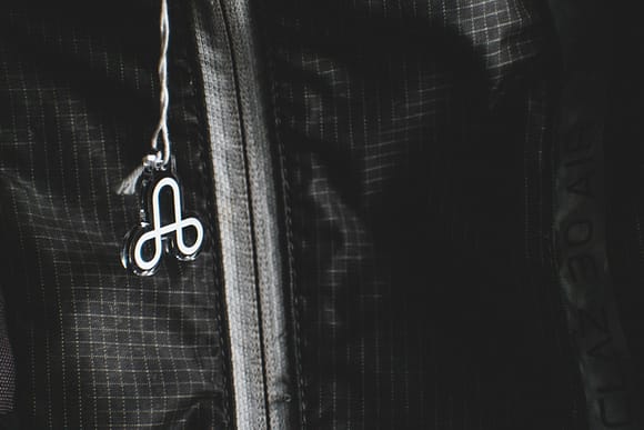 A backpack displaying the acrylic charm featuring the logo